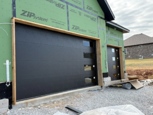 Two modern black garage doors installed on a new construction home by Ozarks Overhead Door & More in Springfield, MO.