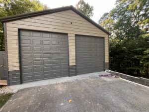 Two modern brown garage doors installed on a metal outbuilding by Knox Garage Door Service LLC in Knoxville, TN.