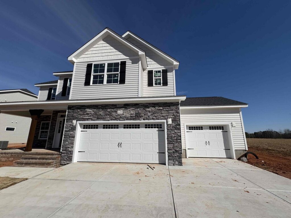 Two brown garage doors installed on a metal-sided building by Skylift Garage Doors - Knoxville, TN