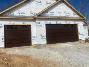 Two brown panel garage doors installed on a new construction home by 314 Overhead Doors in O'Fallon, MO.