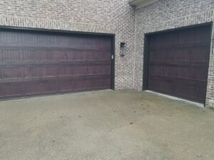 Two brown garage doors, one large and one small, on a brick home, installed by Door-Tech LLC in Lexington, KY.
