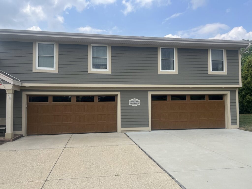 Two newly installed brown residential garage doors with top windows by McDonald Overhead Door Inc. in Kenosha, WI.