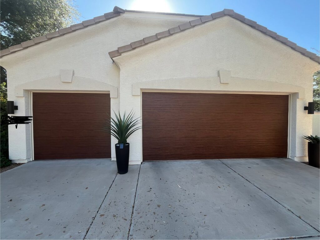 Two brown wood-look garage doors installed on a residential home by Stapley Action Garage Door in Mesa, AZ.