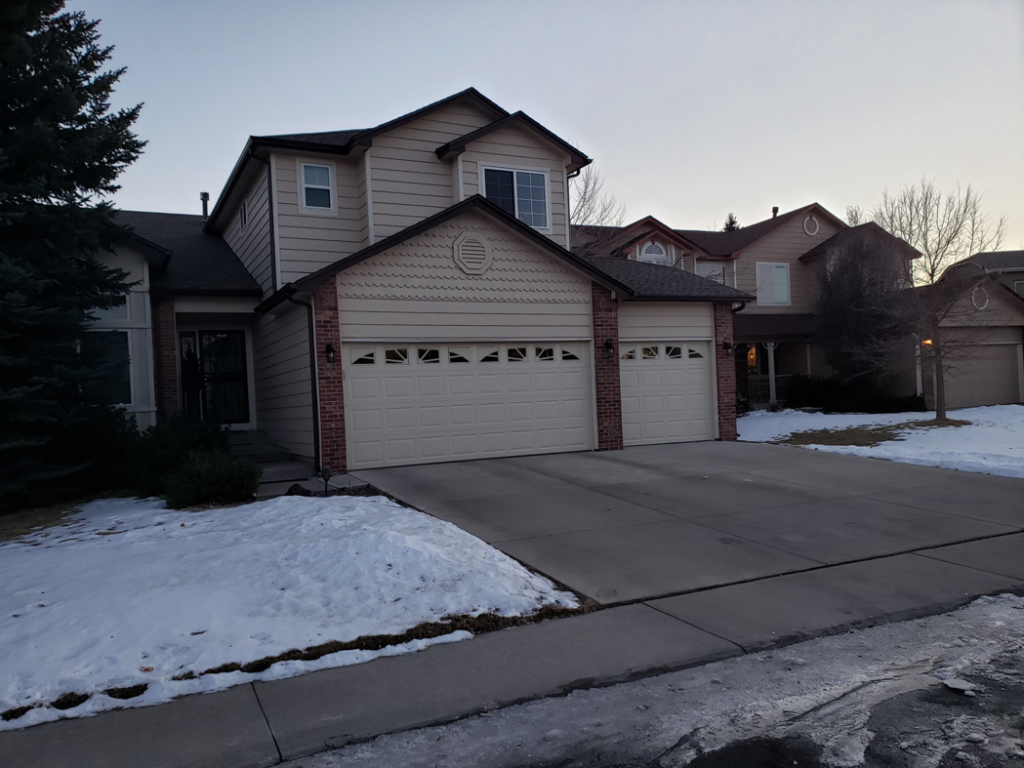 A residential house featuring two garage doors installed by 170 Springs LLC Garage Doors in Aurora, CO