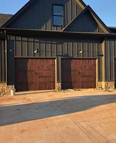 Two dark brown garage doors with decorative hardware on a modern building by Summers Garage Door in Denver, CO.