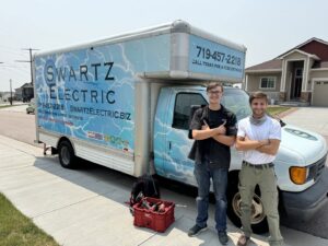Two electricians from Swartz Electric standing with their service truck and tools in Colorado Springs, CO.