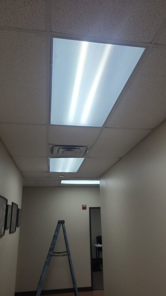 Two electricians from LeoElectricservice working on an electrical panel and wiring in Frisco, TX.