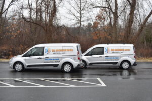 Two branded HVAC service vans parked side-by-side, ready for calls from Top Mechanical Service in East Longmeadow, MA.