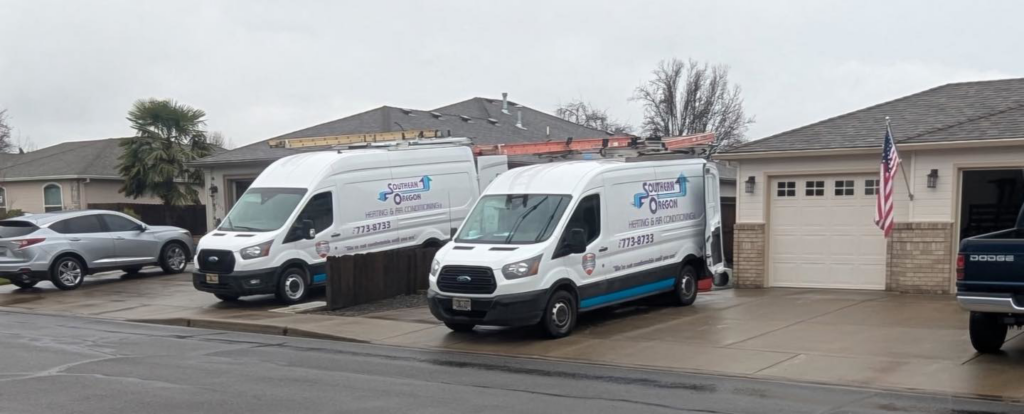 Two branded HVAC service vans from Southern Oregon Heating & Air Conditioning parked in Medford, OR