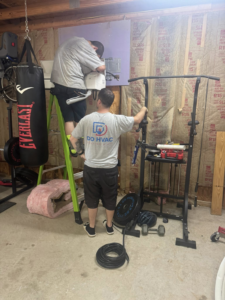 Two HVAC technicians installing a mini-split indoor unit for DD HVAC PROS in Charlotte, NC.