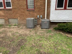 Two outdoor Lennox air conditioning units installed next to a brick house by Heating and Cooling Drs of Waukesha, Pewaukee, and Delafield, Waukesha, WI.