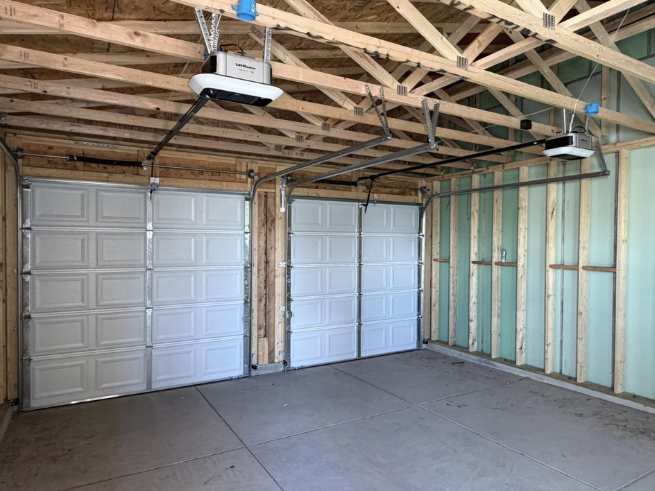 Two LiftMaster garage door openers and white garage doors newly installed in a garage by 365GarageDoor in Dallas, TX