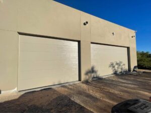 Two light-colored modern garage doors installed on a building by Morning Star Garage Doors in Phoenix, AZ.
