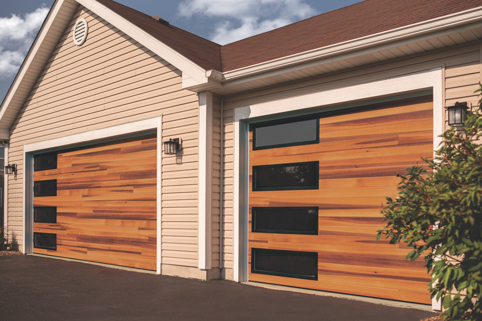 Two modern wooden garage doors with black windows installed by Fireside Home Solutions in Portland, OR.