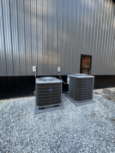 Two outdoor AC condenser units installed next to a commercial building by AAA Heating & Air Conditioning Service Inc. in Lexington, KY.