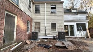 Two outdoor air conditioning condenser units installed next to an older residential building by Express Home Services LLC in Las Vegas, NV.