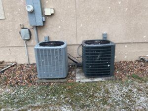 Two outdoor AC condenser units installed next to a home by Simple Valley Heating and Cooling in Orem, UT