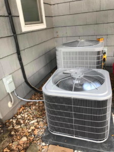 Two outdoor air conditioning units installed next to a residential building by Arrowhead Mechanical HVAC in Woodville, OH