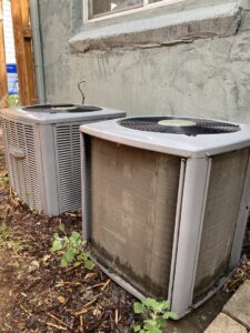 Two outdoor air conditioning units, one appearing older, ready for service or replacement by Fix It Now Heating and Cooling in Thornton, CO