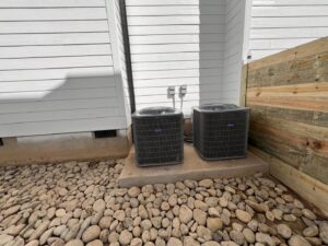 Two outdoor AC units installed next to a building by M&S Heating and Air Conditioning in Mechanicsville, MD