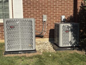 Two outdoor air conditioning units installed next to a brick house by Baker Heating & Cooling in Dayton, OH.