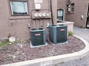 Two outdoor air conditioning units installed next to a building by Bean'z Heating and Cooling in Chicago, IL.