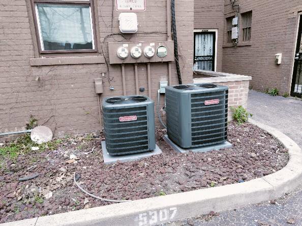 Two outdoor air conditioning units installed next to a building by Bean'z Heating and Cooling in Chicago, IL.