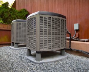 Two outdoor air conditioning units professionally installed on a gravel bed by Netherland Air Conditioning LLC in Mobile, AL.