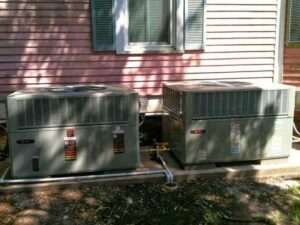 Two outdoor air conditioning units professionally installed next to a residential building by R&B Cooling&Heating in Abbeville, LA.