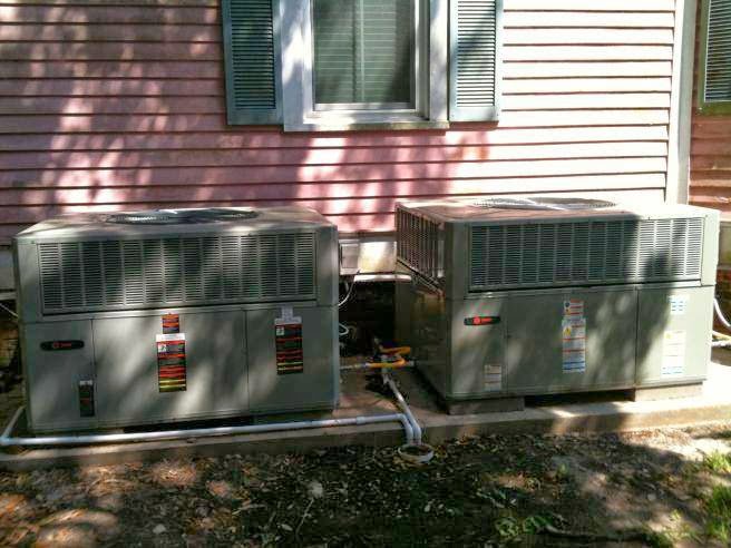 Two outdoor air conditioning units professionally installed next to a residential building by R&B Cooling&Heating in Abbeville, LA.