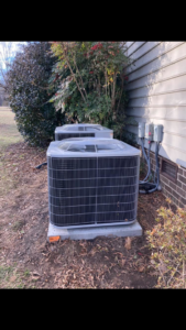 Two outdoor AC units installed next to a residential building, showcasing HVAC equipment by Your Angel Heating And Cooling LLC in Cary, NC.