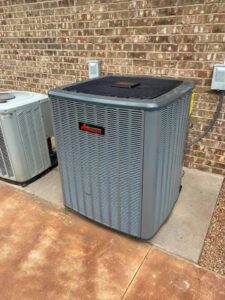 Two outdoor air conditioning units installed next to a brick wall, serviced by Full Send Plumbing Heating & Cooling in Stillwater, OK.