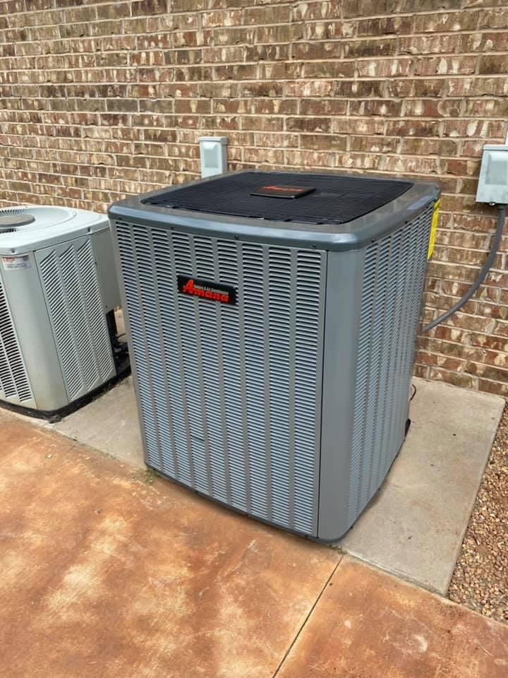 Two outdoor air conditioning units installed next to a brick wall, serviced by Full Send Plumbing Heating & Cooling in Stillwater, OK.