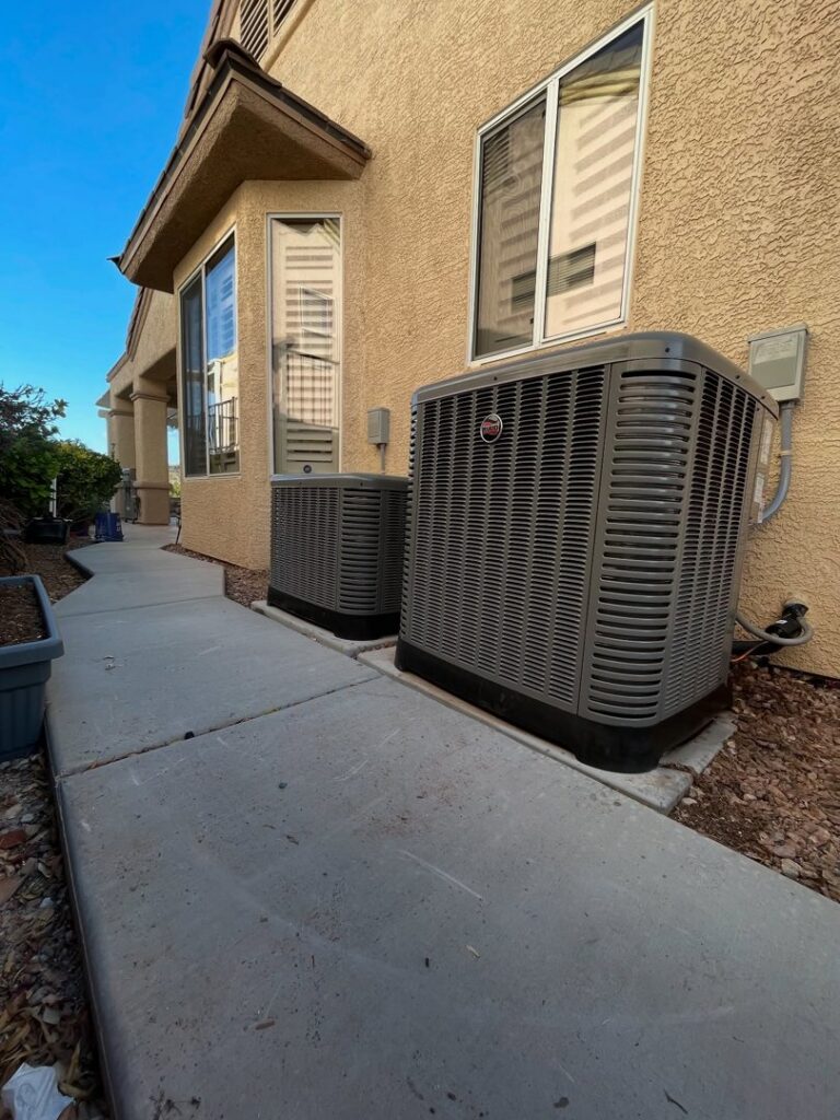 Two outdoor air conditioning units installed next to a residential building by Cool Camel HVAC in Henderson, NV
