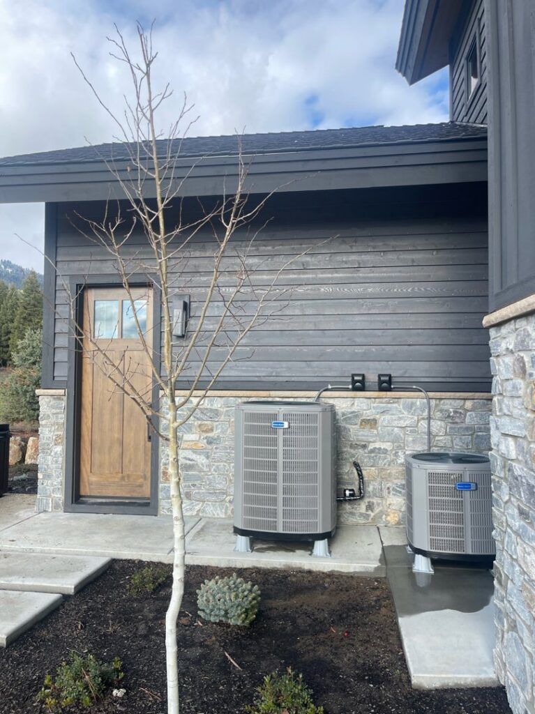 Two outdoor air conditioning units installed next to a modern home by Boise Valley Heating & Air in Meridian, ID