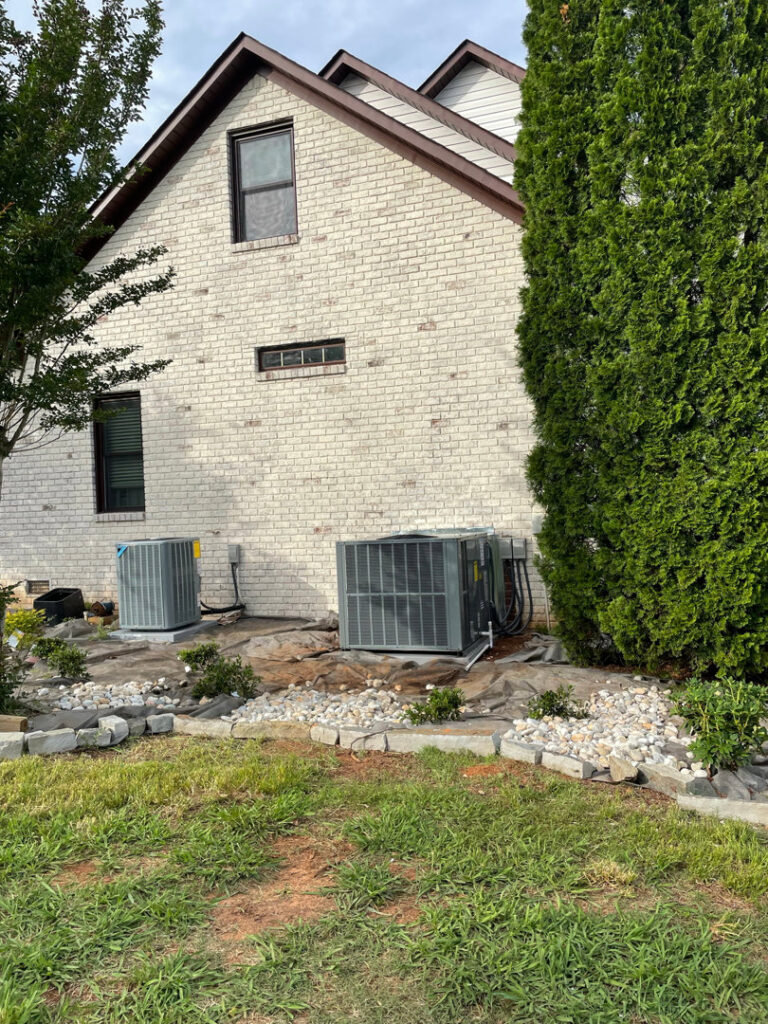 Two outdoor HVAC condenser units installed next to a residential building, serviced by Bama Air Systems in Cullman, AL.