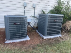 Two newly installed outdoor HVAC condenser units next to a residential building by Summit Service Heating and Air in Hilton Head Island, SC.