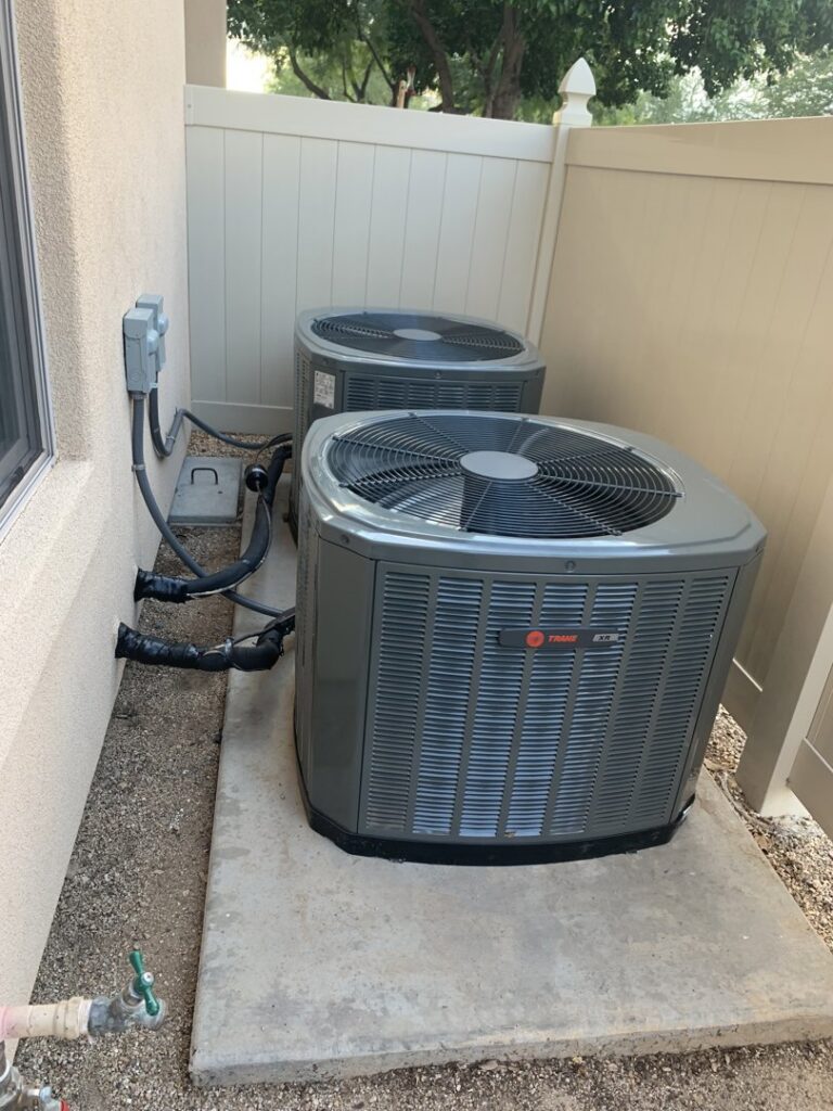 Two outdoor Trane HVAC units installed next to a building by Advanced Comfort A/C & Heating in Phoenix, AZ.