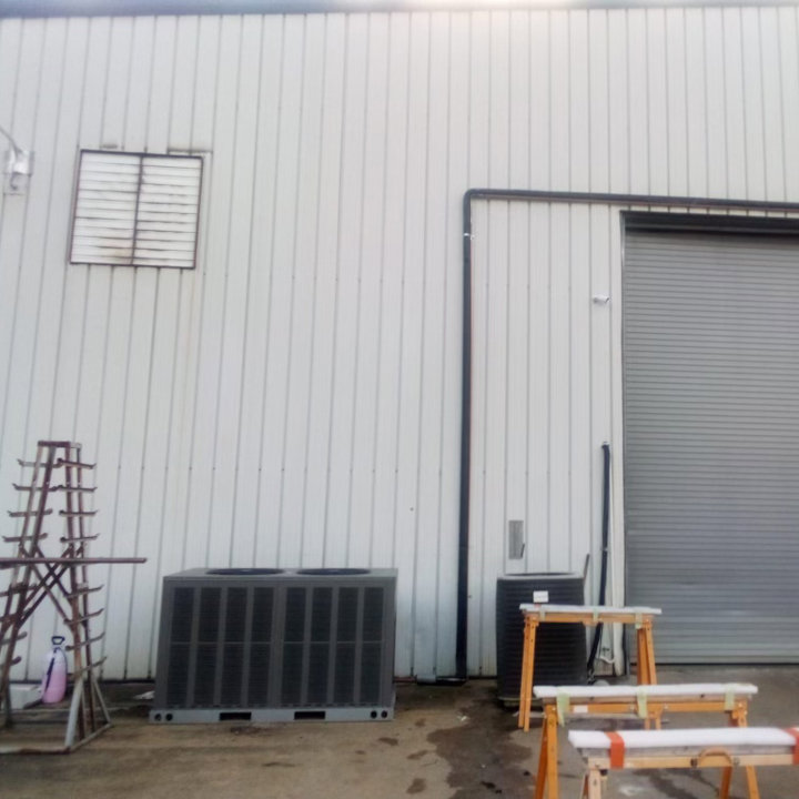 Two outdoor HVAC condenser units positioned next to a commercial building, indicating installation or service by Eleven Heating and Cooling in Birmingham, AL.