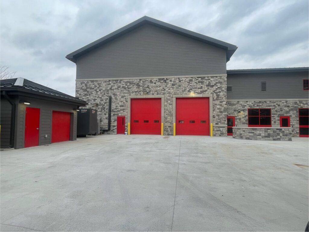 Two red commercial garage doors installed on a large building by Affordable Overhead Garage Door in Modesto, CA