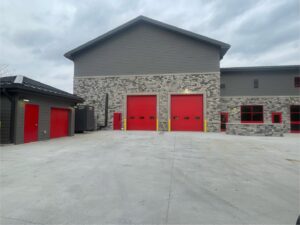Two red commercial garage doors installed on a large building by Affordable Overhead Garage Door in Modesto, CA