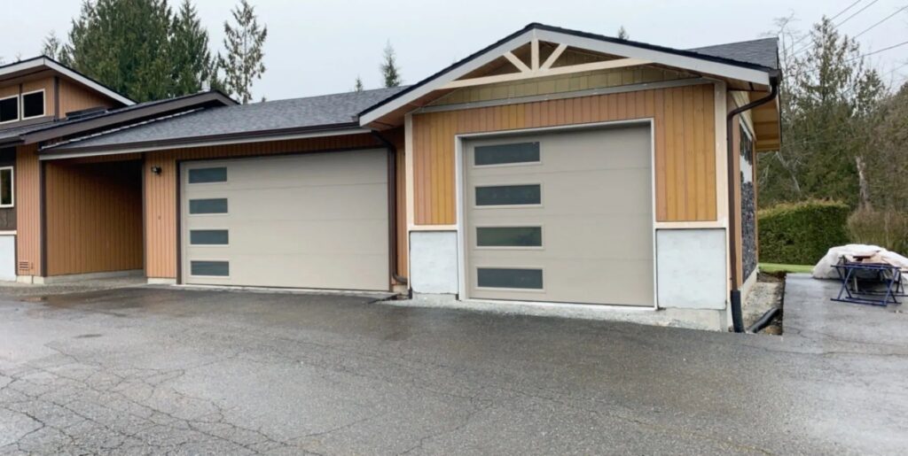 Two tan modern garage doors with horizontal windows installed by Overhead Door Company of Everett, Inc in Everett, WA.