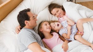 Two technicians working together on an outdoor HVAC unit, performing service for Stevens Refrigeration & Heating in Enid, OK