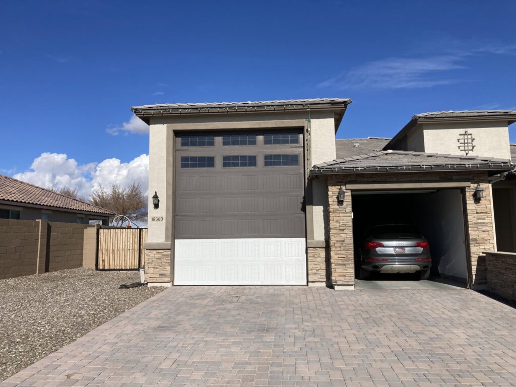A newly installed two-tone garage door with top windows by Anew Garage by Jon's Garages in Surprise, AZ.