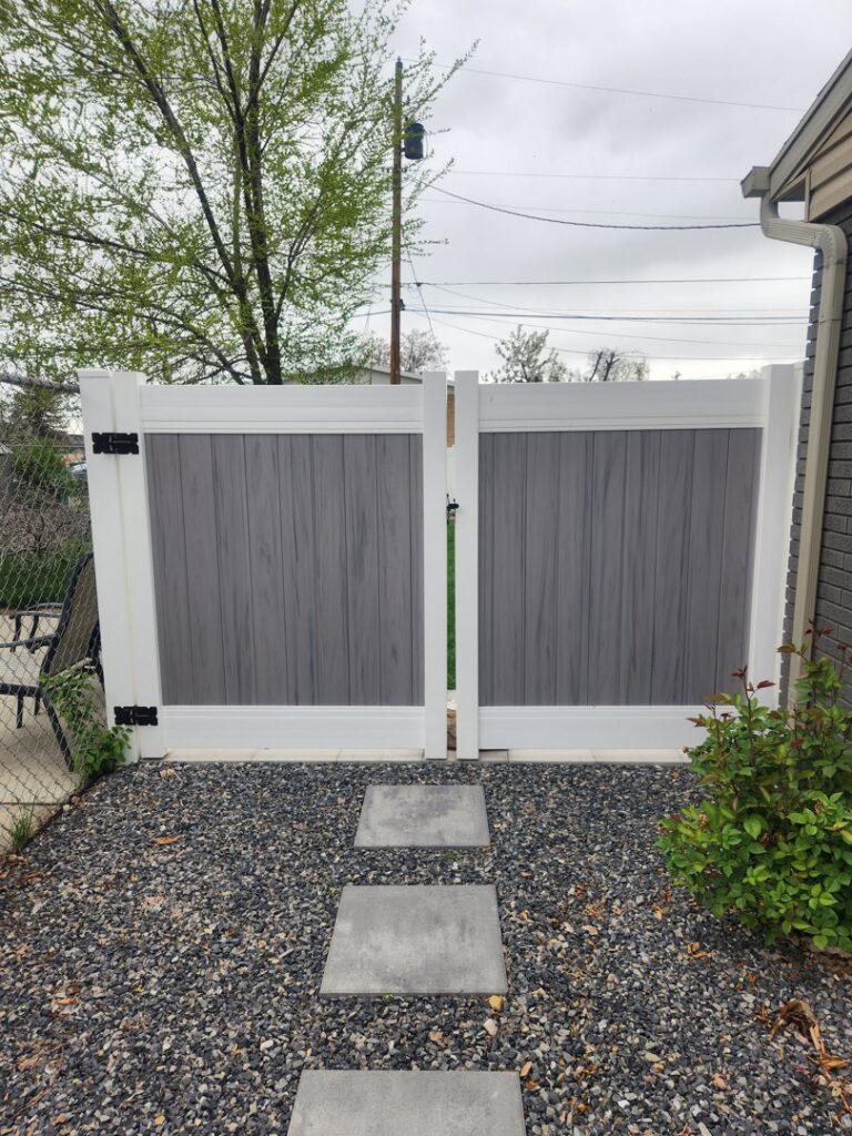 A modern two-tone grey and white vinyl fence with a double gate, installed by All American Vinyl in Provo, UT.