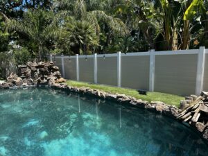 A modern two-tone privacy fence (tan and white) installed alongside a swimming pool by Superior Fence & Rail in San Jose, CA.