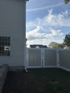 A two-tone vinyl fence with a double gate installed by Camp Carlson Fencing in Rochester, NY, for wider access.