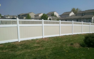 A newly installed two-tone vinyl privacy fence in a residential backyard by Global Supply in Lindon, UT.