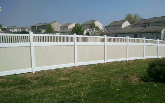 A newly installed two-tone vinyl privacy fence in a residential backyard by Global Supply in Lindon, UT.