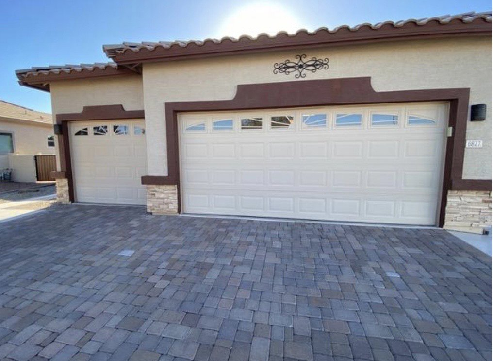 Two traditional style garage doors with arched windows installed by Blue Fox Garage Doors in Gilbert, AZ.